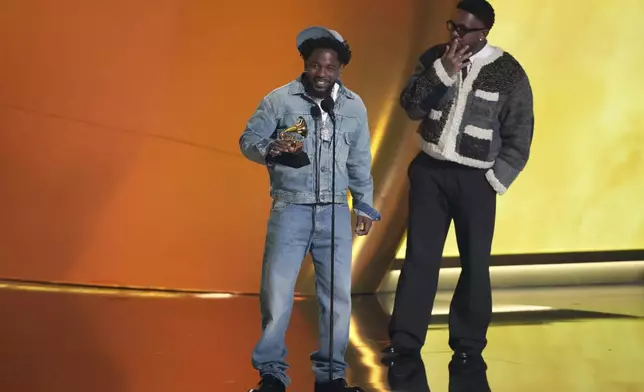 Kendrick Lamar, left, accepts the record of the year award for "Not Like Us during the 67th annual Grammy Awards on Sunday, Feb. 2, 2025, in Los Angeles. Mustard looks on from right. (AP Photo/Chris Pizzello)