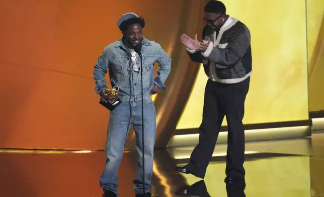 Kendrick Lamar, left, accepts the record of the year award for "Not Like Us during the 67th annual Grammy Awards on Sunday, Feb. 2, 2025, in Los Angeles. Mustard looks on from right. (AP Photo/Chris Pizzello)