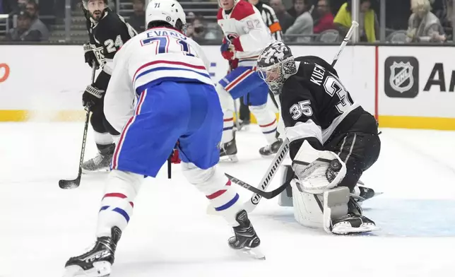 Los Angeles Kings goaltender Darcy Kuemper, right, makes a glove save as Montreal Canadiens center Jake Evans tries to redirect during the first period of an NHL hockey game, Wednesday, Feb. 5, 2025, in Los Angeles. (AP Photo/Mark J. Terrill)
