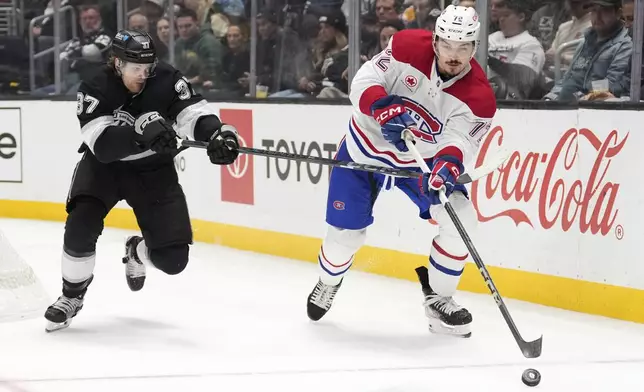 Montreal Canadiens defenseman Arber Xhekaj, right moves the puck as Los Angeles Kings left wing Warren Foegele reaches in during the second period of an NHL hockey game, Wednesday, Feb. 5, 2025, in Los Angeles. (AP Photo/Mark J. Terrill)