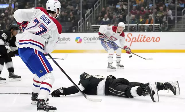 Montreal Canadiens center Kirby Dach, left, passes the puck to defenseman Lane Hutson, right, as Los Angeles Kings defenseman Drew Doughty dives between them during the first period of an NHL hockey game, Wednesday, Feb. 5, 2025, in Los Angeles. (AP Photo/Mark J. Terrill)
