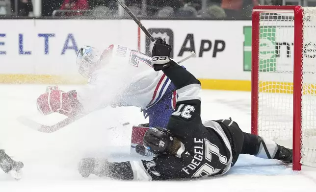 Montreal Canadiens goaltender Jakub Dobes, left, stops a shot as Los Angeles Kings left wing Warren Foegele, right, falls after being taken down by defenseman Logan Mailloux which resulted in a penalty shot with Foegele scoring during the second period of an NHL hockey game, Wednesday, Feb. 5, 2025, in Los Angeles. (AP Photo/Mark J. Terrill)