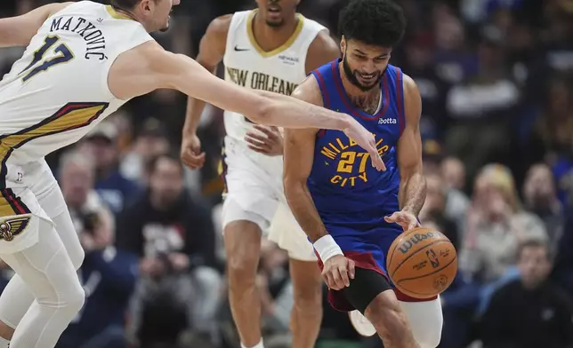 Denver Nuggets guard Jamal Murray, right, dodges New Orleans Pelicans center Karlo Matkovic, left, to pick up the ball in the first half of an NBA basketball game Monday, Feb. 3, 2025, in Denver. (AP Photo/David Zalubowski)