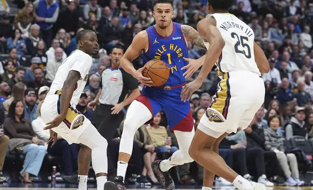 Denver Nuggets forward Michael Porter Jr., center, drives to the basket as New Orleans Pelicans guards Javonte Green, left, and Trey Murphy III, right, defend in the first half of an NBA basketball game Monday, Feb. 3, 2025, in Denver. (AP Photo/David Zalubowski)