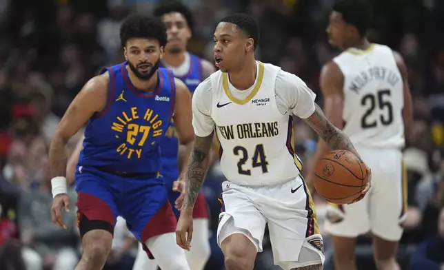 New Orleans Pelicans guard Jordan Hawkins (24) looks to pass the ball as Denver Nuggets guard Jamal Murray (27) defends in the first half of an NBA basketball game Monday, Feb. 3, 2025, in Denver. (AP Photo/David Zalubowski)