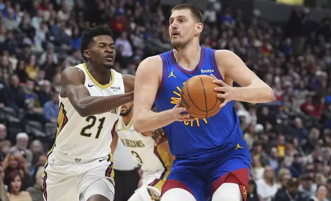 Denver Nuggets center Nikola Jokic, right, drives to the basket as New Orleans Pelicans center Yves Missi (21) defends in the first half of an NBA basketball game Monday, Feb. 3, 2025, in Denver. (AP Photo/David Zalubowski)