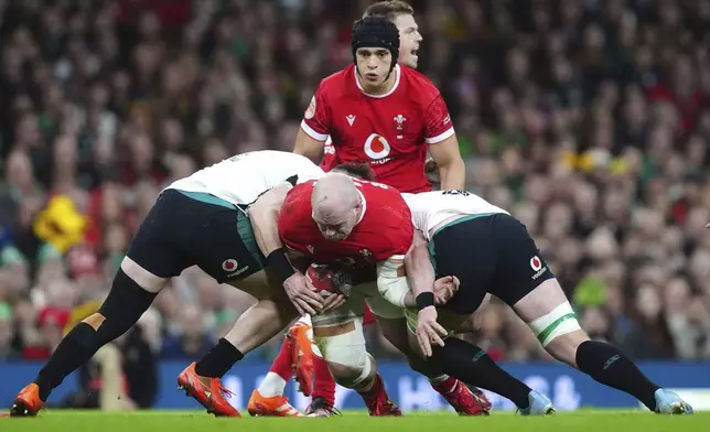 Wales' WillGriff John tackled by Ireland's Dan Sheehan and Joe McCarthy, during the Six Nations rugby match between Wales and Ireland, at the Principality Stadium, in Cardiff, Wales, Saturday, Feb. 22, 2025. (David Davies/PA via AP)