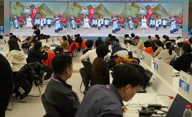 Journalists watch the parade of North Korea team during the opening ceremony of the 9th Asian Winter Games in Harbin, China on Friday, Feb. 7, 2025. (AP Photo/Aaron Favila)