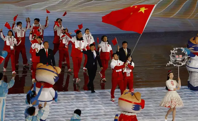 Flag bearers Ning Zhongyan and Liu Mengting of China lead their contingent during the parade of athletes at the opening ceremony of the 9th Asian Winter Games in Harbin, China, Friday, Feb. 7, 2025. (Issei Kato/Pool Photo via AP)