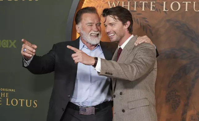 Arnold Schwarzenegger, left, and Patrick Schwarzenegger give the thumbs up at the season three premiere of "The White Lotus" on Monday, Feb. 10, 2025, at Paramount Theater in Los Angeles. (AP Photo/Chris Pizzello)