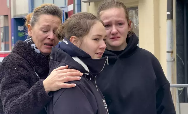 People mourn at the site of stabbing a day after an attack that left a 14-year-old dead and five others injured, in Villach, Austria, Sunday, Feb. 16, 2025. (AP Photo/Darko Bandic)