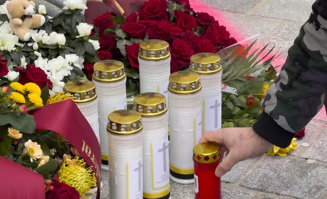A man lights a candle at the site of stabbing a day after an attack that left a 14-year-old dead and five others injured, in Villach, Austria, Sunday, Feb. 16, 2025. (AP Photo/Darko Bandic)