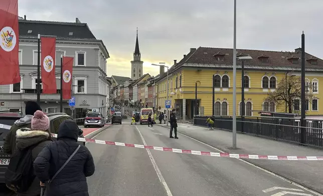 People look into a cordoned off area where a 23-year-old man stabbed several people in the southern Austria city of Villach, Saturday, Feb. 15, 2025. (Wiesflecker/Kleine Zeitung via AP)