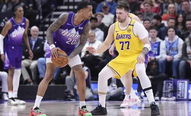 Utah Jazz forward John Collins (20) holds the ball against Los Angeles Lakers guard Luka Doncic (77) during the first half of an NBA basketball game, Wednesday, Feb. 12, 2025, in Salt Lake City. (AP Photo/Rob Gray)