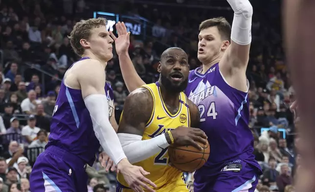Los Angeles Lakers forward LeBron James, middle, drives between Utah Jazz forward Lauri Markkanen, left, and center Walker Kessler (24) during the first quarter of an NBA basketball game, Wednesday, Feb. 12, 2025, in Salt Lake City. (AP Photo/Rob Gray)