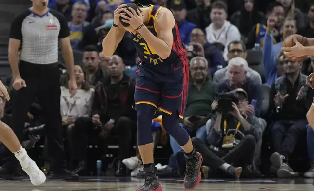 Golden State Warriors guard Stephen Curry holds onto his head after scoring against the Phoenix Suns during the first half of an NBA basketball game in San Francisco, Friday, Jan. 31, 2025. (AP Photo/Jeff Chiu)