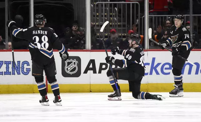 Washington Capitals left wing Pierre-Luc Dubois (80) celebrates after his goal with defenseman Rasmus Sandin (38) and defenseman John Carlson (74) during the second period of an NHL hockey game against the Winnipeg Jets, Saturday, Feb. 1, 2025, in Washington. (AP Photo/Nick Wass)