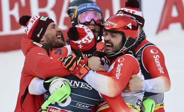 Clockwise from left, Switzerland's Alexis Monney, Stefan Rogentin, Loic Meillard, Marc Rochat and Nef Tanguy celebrate at the finish area of a men's team combined event, at the Alpine Ski World Championships, in Saalbach-Hinterglemm, Austria, Wednesday, Feb. 12, 2025. (AP Photo/Marco Trovati)