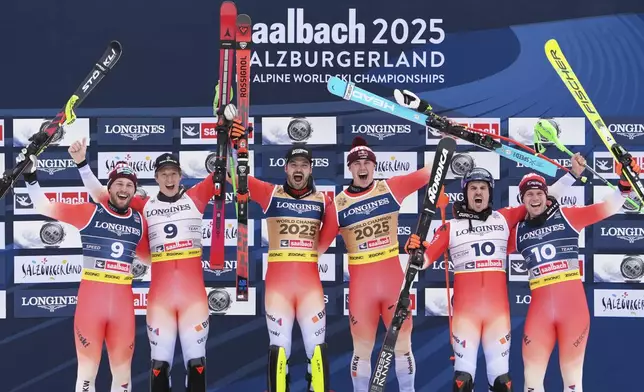 Switzerland's Loic Meillard, third from left, and teammate Franjo von Allmen, third from right, celebrate on the podium after winning the gold medal in a men's team combined event, with silver medalists Switzerland's Alexis Monney, left, and teammate Nef Tanguy, and and bronze medalists Switzerland's Marc Rochat, second from right, and teammate Stefan Rogentin, at the Alpine Ski World Championships, in Saalbach-Hinterglemm, Austria, Wednesday, Feb. 12, 2025. (AP Photo/Giovanni Auletta)