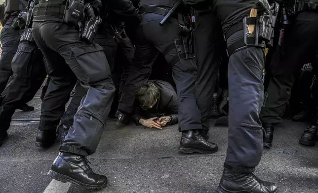 Police officers remove anti-far-right protesters blocking the route of a far right demonstration, a day before the German election, in Berlin, Germany, Saturday, Feb. 22, 2025. (AP Photo/Ebrahim Noroozi)