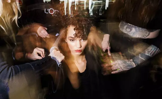 Makeup artists work backstage prior a fashion show at the Mercedes-Benz Fashion Week in Madrid, Friday, Feb. 21, 2025. (AP Photo/Bernat Armangue)
