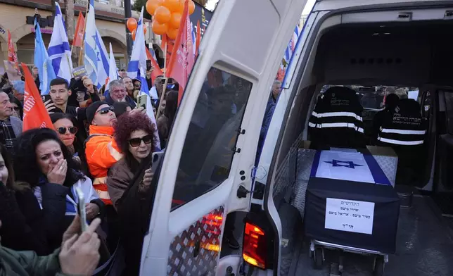 Mourners gather around the car carrying the coffins of slain hostages Shiri Bibas and her two children, Ariel and Kfir, during their funeral procession in Rishon Lezion, Israel, Wednesday, Feb. 26, 2025. (AP Photo/Ariel Schalit)