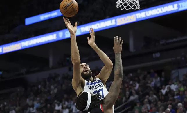 Minnesota Timberwolves center Rudy Gobert shoots against Portland Trail Blazers center Robert Williams III during the first half of an NBA basketball game, Saturday, Feb. 8, 2025, in Minneapolis. (AP Photo/Ellen Schmidt)
