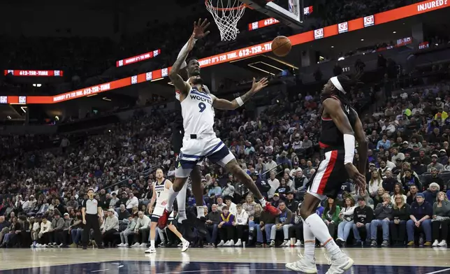 Minnesota Timberwolves guard Nickeil Alexander-Walker loses control of the ball while shooting as Portland Trail Blazers center Deandre Ayton, behind center, defends during the first half of an NBA basketball game, Saturday, Feb. 8, 2025, in Minneapolis. (AP Photo/Ellen Schmidt)