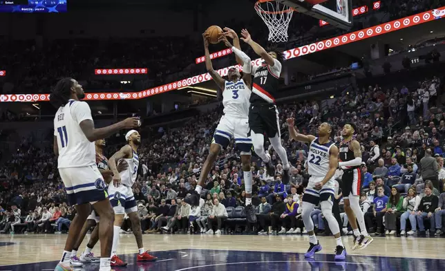 Minnesota Timberwolves forward Jaden McDaniels (3) grabs a rebound against Portland Trail Blazers guard Shaedon Sharpe (17) during the second half of an NBA basketball game, Saturday, Feb. 8, 2025, in Minneapolis. (AP Photo/Ellen Schmidt)
