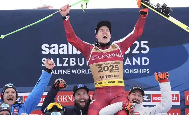 Austria's Raphael Haaser celebrates with team after winning the gold medal in a men's giant slalom, at the Alpine Ski World Championships, in Saalbach-Hinterglemm, Austria, Friday, Feb. 14, 2025. (AP Photo/Giovanni Auletta)
