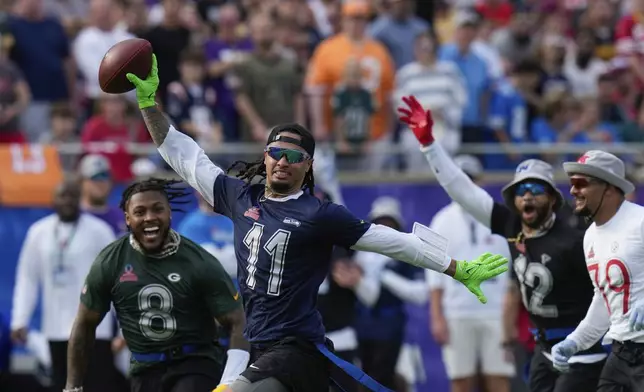 NFC wide receiver Jaxon Smith-Njigba (11), of the Seattle Seahawks, celebrates on his way to scoring a touchdown during the flag football event at the NFL Pro Bowl, Sunday, Feb. 2, 2025, in Orlando. (AP Photo/Chris O'Meara)