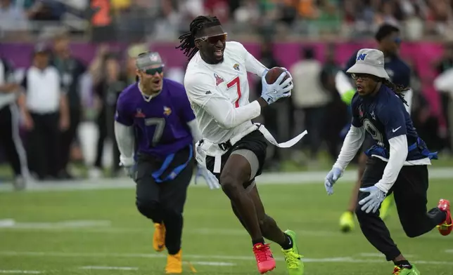 AFC wide receiver Brian Thomas Jr. (7), of the Jacksonville Jaguars, runs away from NFC return specialist KaVontae Turpin, of the Dallas Cowboys, right, during the flag football event at the NFL Pro Bowl, Sunday, Feb. 2, 2025, in Orlando. (AP Photo/Chris O'Meara)