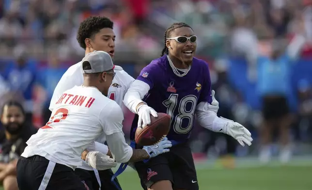 NFC wide receiver Justin Jefferson (18), of the Minnesota Vikings, scores a touchdown next to AFC cornerback Pat Surtain II, of the Denver Broncos, left, and safety Kyle Hamilton, of the Baltimore Ravens, during the flag football event at the NFL Pro Bowl, Sunday, Feb. 2, 2025, in Orlando. (AP Photo/Chris O'Meara)