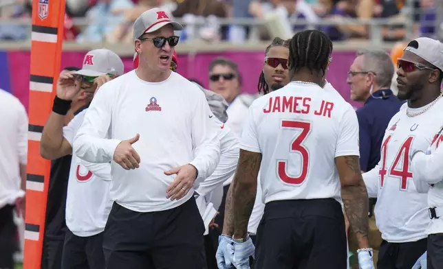 AFC coach Peyton Manning, left, talks to players before the flag football event at the NFL Pro Bowl, Sunday, Feb. 2, 2025, in Orlando. (AP Photo/Chris O'Meara)