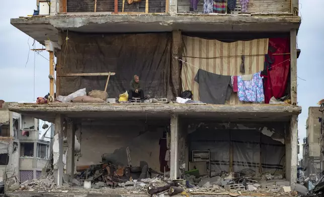 A man sits in his partially standing home, covered with sheets as makeshift walls, in an area largely destroyed by the Israeli army's air and ground offensive in Jabaliya, Gaza Strip, on Tuesday, Feb. 11, 2025. (AP Photo/Jehad Alshrafi)