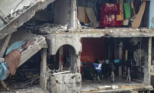 Palestinian children play in a partially standing home, in an area largely destroyed by the Israeli army's air and ground offensive in Jabaliya, Gaza Strip, on Tuesday, Feb. 11, 2025. (AP Photo/Jehad Alshrafi)