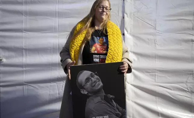 FILE - Herut Nimrodi poses for a portrait with a poster of her son, Tamir Nimrodi, an Israeli soldier taken hostage on Oct. 7, 2023, and being held by Hamas militants in the Gaza Strip, at a rally for hostages and their families in Tel Aviv, Israel, Jan. 14, 2025. (AP Photo/Maya Alleruzzo, File)