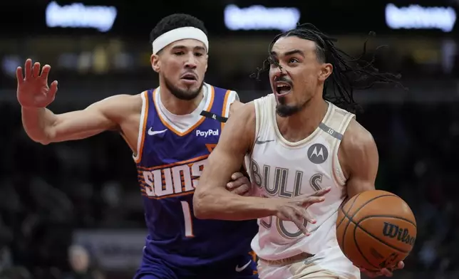 Phoenix Suns guard Devin Booker (1), left, guards Chicago Bulls guard Tre Jones (30) during the first half of an NBA basketball game Saturday, Feb. 22, 2025, in Chicago. (AP Photo/Erin Hooley)