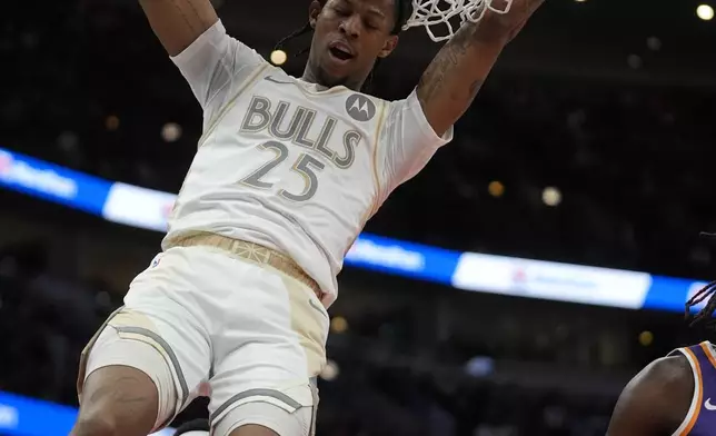 Chicago Bulls forward Dalen Terry (25) swings from the net after dunking the ball during the first half of an NBA basketball game against the Phoenix Suns, Saturday, Feb. 22, 2025, in Chicago. (AP Photo/Erin Hooley)
