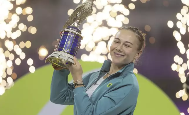 Amanda Anisimova of the United States holds the trophy after winning the Qatar Open tennis tournament in Doha, Qatar, on Saturday, Feb. 15, 2025. (AP Photo/Hussein Sayed)