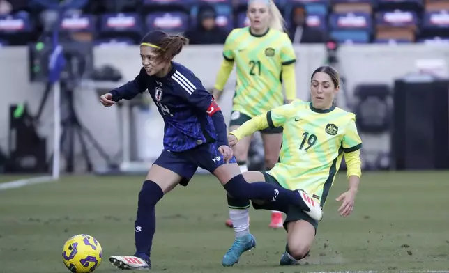 Japan midfielder Yui Hasegawa, left, gets control of the ball as Australia midfielder Katrina Gorry (19) falls during the SheBelieves Cup women's soccer tournament, Thursday, Feb. 20, 2025, in Houston. (AP Photo/Michael Wyke)