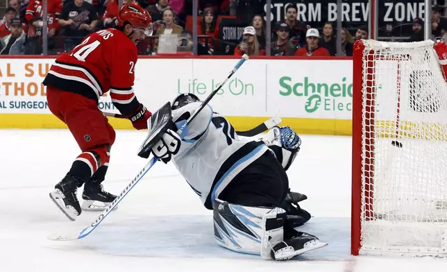 Carolina Hurricanes' Seth Jarvis (24) shoots the puck past Utah Hockey Club goaltender Karel Vejmelka (70) for a goal during the second period of an NHL hockey game in Raleigh, N.C., Saturday, Feb. 8, 2025. (AP Photo/Karl DeBlaker)