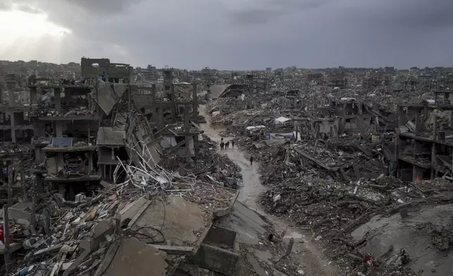 Palestinians walk in the destruction caused by the Israeli air and ground offensive in Jabaliya, Gaza Strip, Thursday, Feb. 6, 2025. (AP Photo/Abdel Kareem Hana)