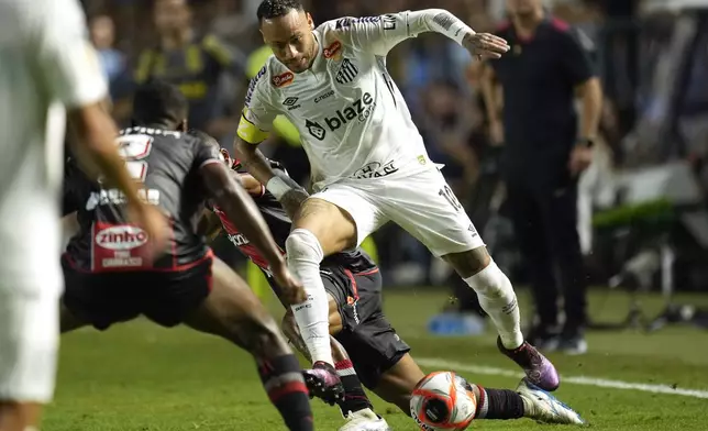 Brazil's Neymar is tackled as he chases a ball during his debut for Santos FC in a Sao Paulo league soccer match against Botafogo-SP, in Santos, Brazil, Wednesday, Feb. 5, 2025. (AP Photo/Andre Penner)