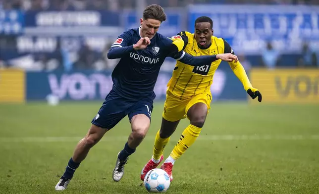Bochum's Tim Oermann, left, and Dortmund's Jamie Gittens, right, challenge for the ball during the German Bundesliga soccer match between VfL Bochum and Borussia Dortmund in Bochum, Germany, Saturday, Feb. 15, 2025. (David Inderlied/dpa via AP)