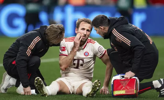 Bayern's Harry Kane receives medical attention during the German Bundesliga soccer match between Bayer Leverkusen and FC Bayern Munich in Leverkusen, Germany, Saturday, Feb. 15, 2025. (Marius Becker/dpa via AP)