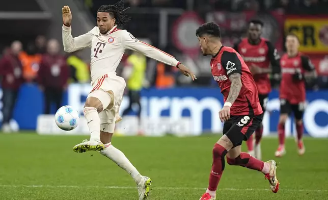 Bayern's Michael Olise, left, controls the ball ahead Leverkusen's Exequiel Palacios during the German Bundesliga soccer match between Bayer Leverkusen and FC Bayern Munich at the BayArena in Leverkusen, Germany, Saturday, Feb. 15, 2025. (AP Photo/Martin Meissner)