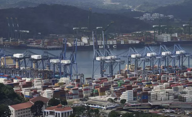 Cargo containers sit stacked as cranes load and unload containers from cargo ships at the Panama Canal's Balboa port, operated by the Panama Ports Company, in Panama City, Friday, Jan. 31, 2025. (AP Photo/Matias Delacroix)
