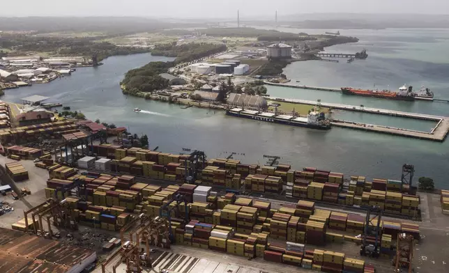 Cargo containers sit stacked as cranes load and unload containers from cargo ships at the Cristobal port, operated by the Panama Ports Company, in Colon, Tuesday, Panama, Feb. 4, 2025. (AP Photo/Matias Delacroix)