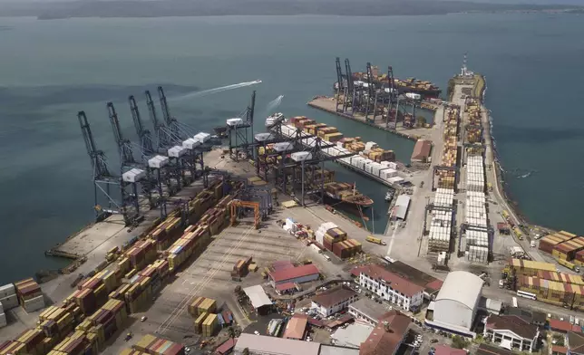 Cargo containers sit stacked as cranes load and unload containers from cargo ships at the Cristobal port, operated by the Panama Ports Company, in Colon, Tuesday, Panama, Feb. 4, 2025. (AP Photo/Matias Delacroix)